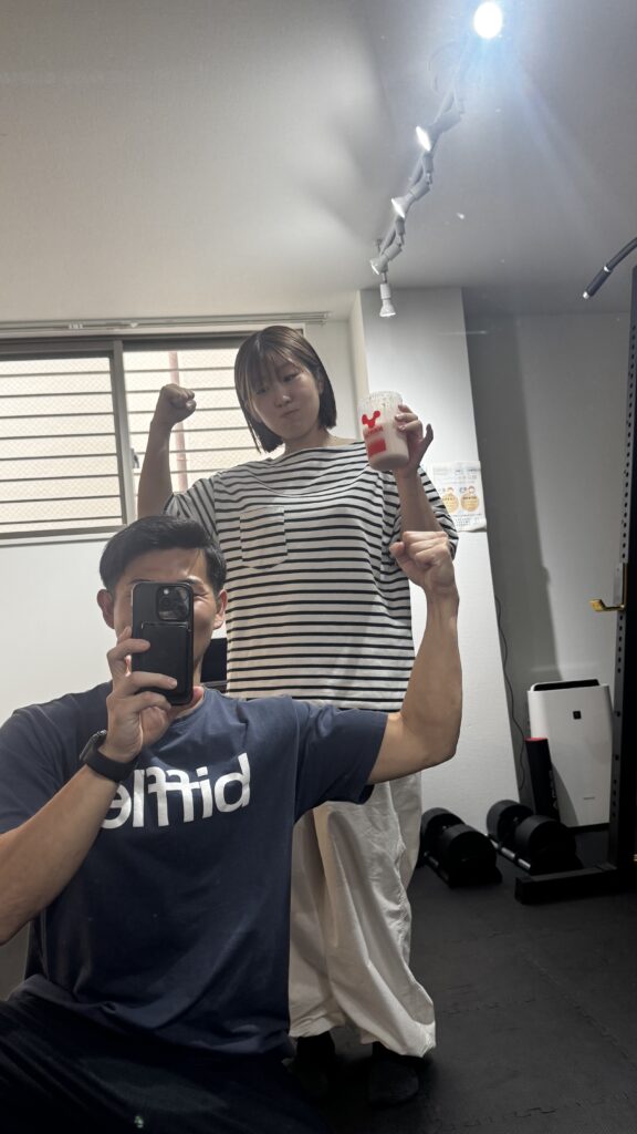 女性とポーズを決めているトレーナー